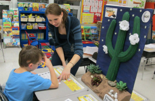 Danielle helps a student answer questions on the pollination activity
